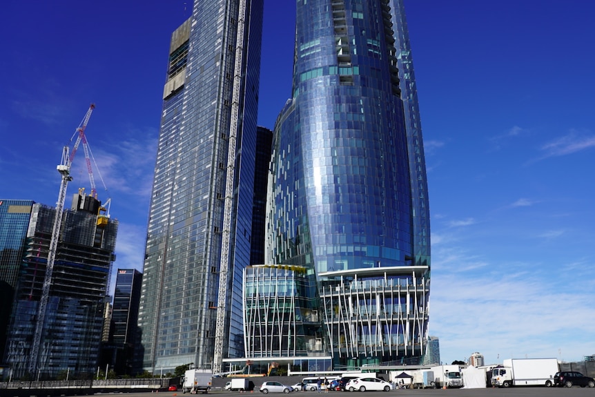 Reflective building against a blue sky and city scape. 