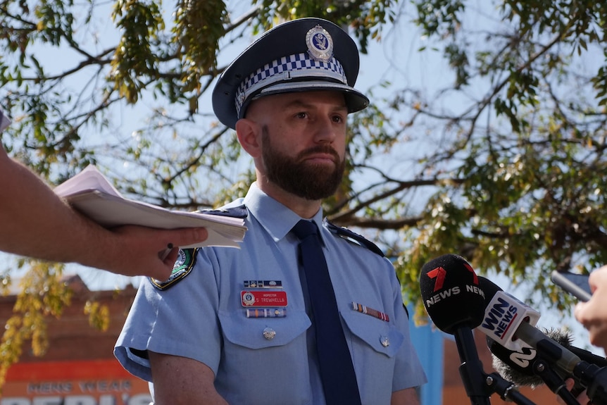A policeman addresses media
