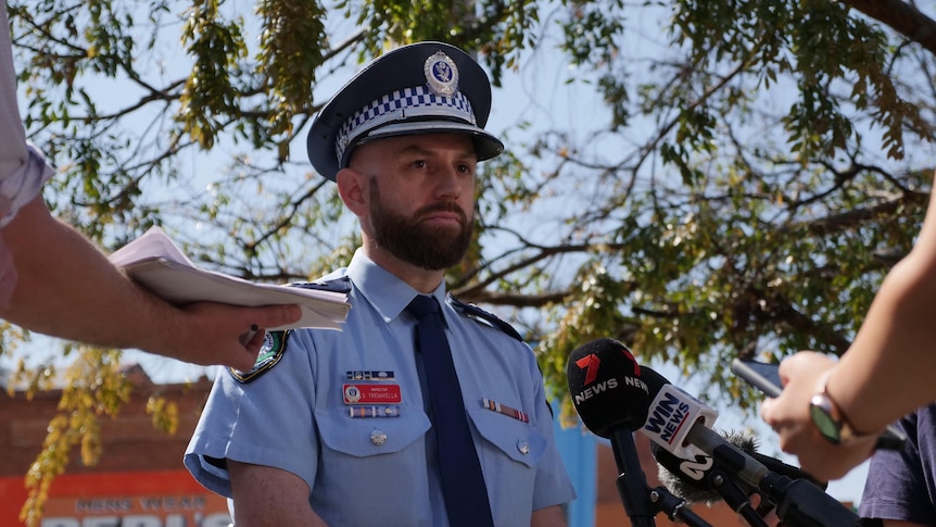 A policeman addresses media