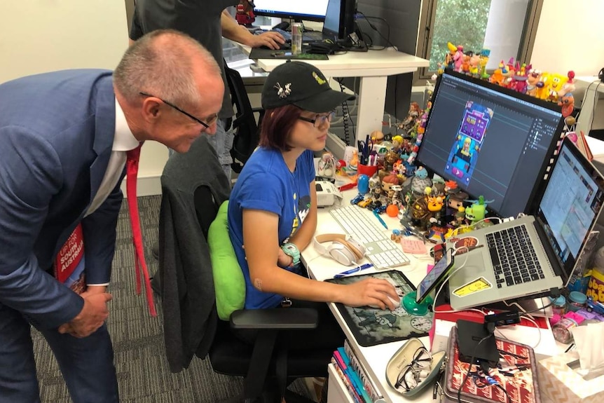 Jay Weatherill watches someone using a computer.