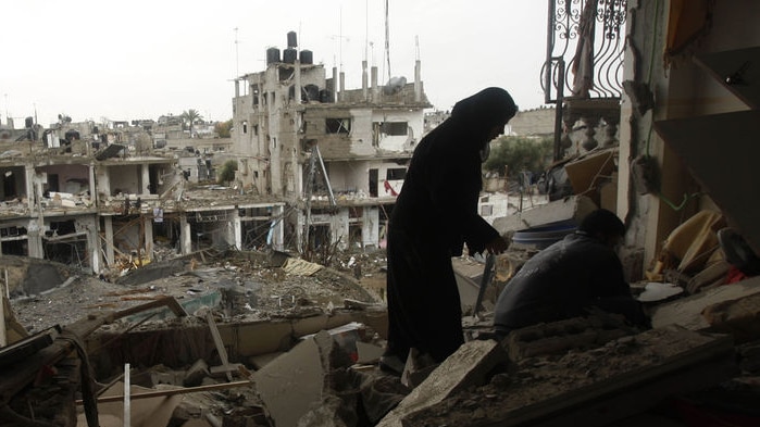 A Palestinian woman surveys her damaged house after an Israeli air strike in Rafah in the southern Gaza Strip on January 1, 2009