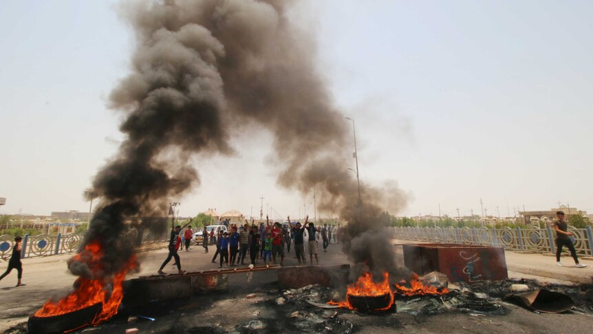 Iraqi protesters burn tires and block the road