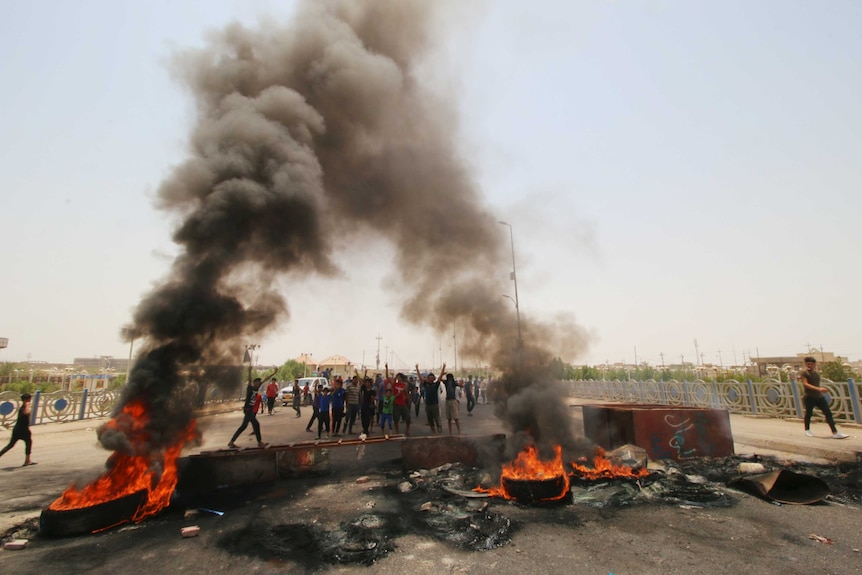 Iraqi protesters burn tires and block the road