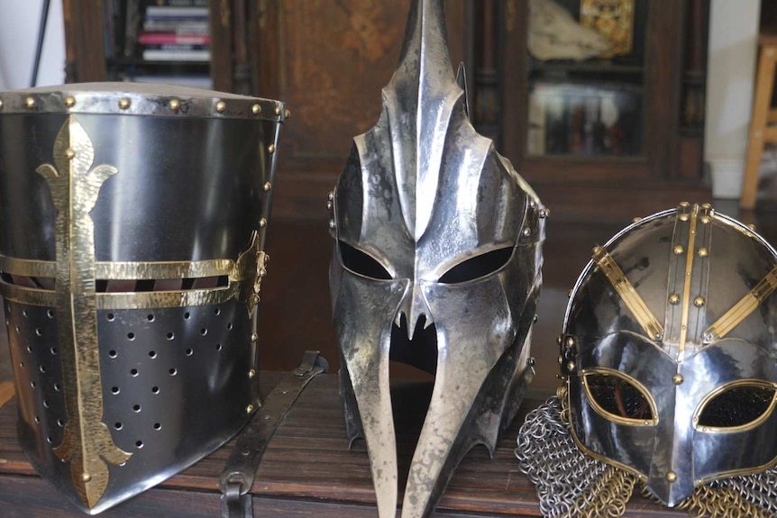 Three metal helmets sitting on a wooden box