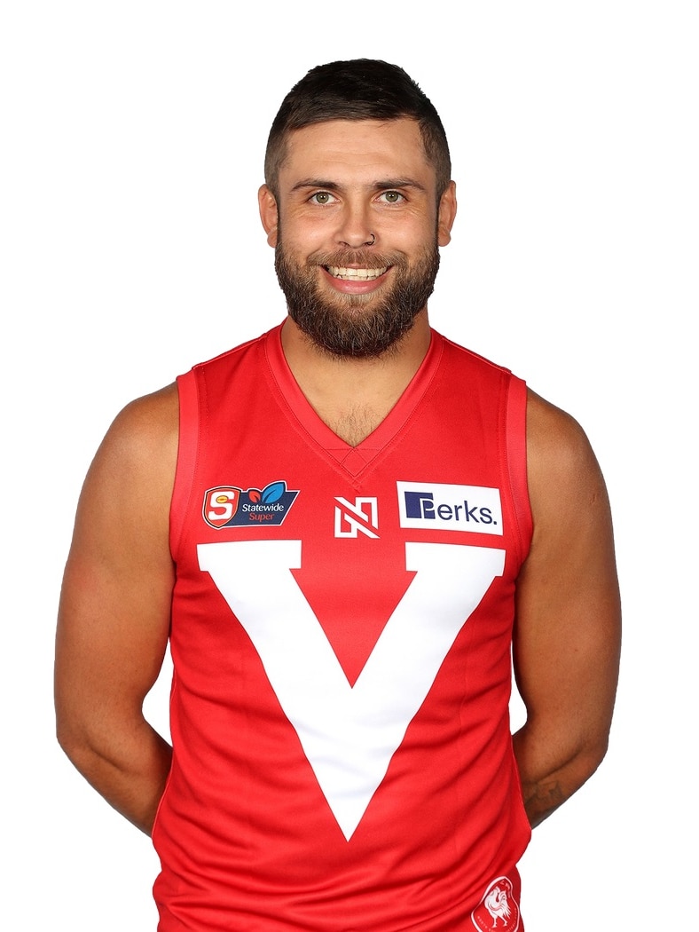 A man wearing a red Australian rules guernsey with a white V on it