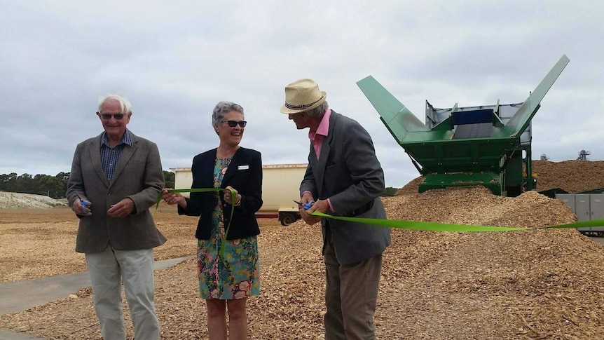 A woman and two men cut the ribbon to open a woodchipping facility in Esperance, WA.