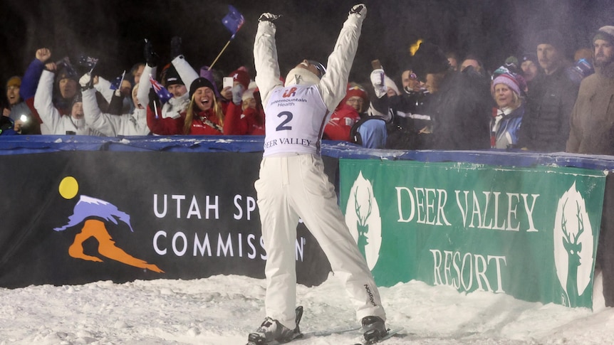 A woman celebrates after a successful ski jump