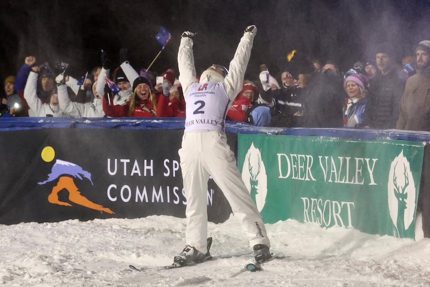 A woman celebrates after a successful ski jump