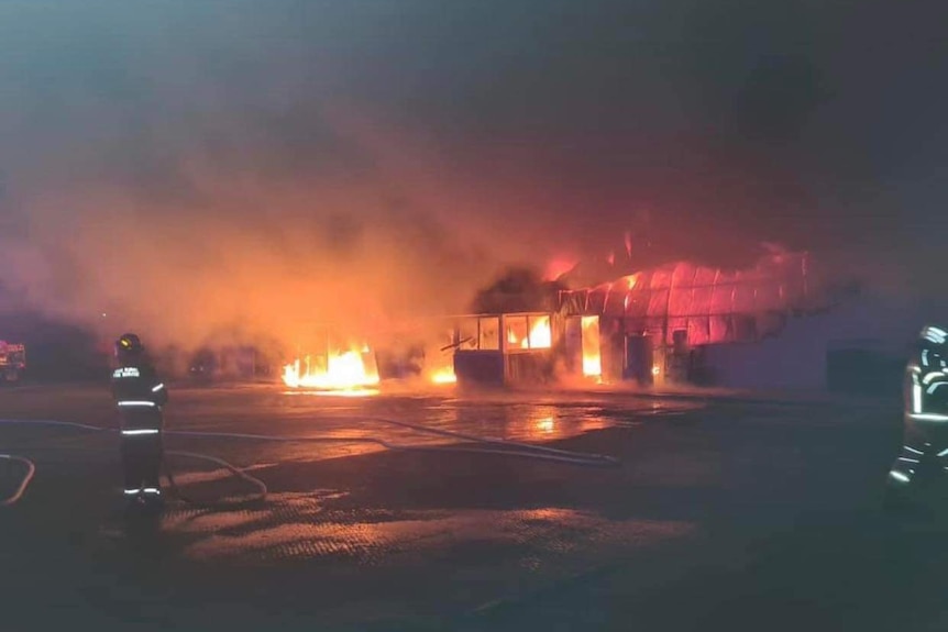 Firefighters attempting to extinguish a blazing fire at a service station.