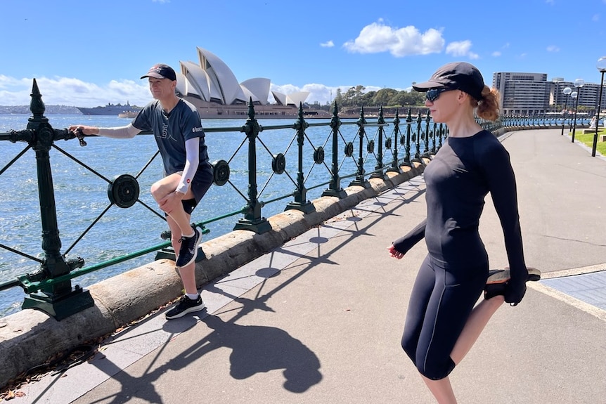 Richard and Georgina stretching their legs, Sydney Harbour and the Opera House behind them.
