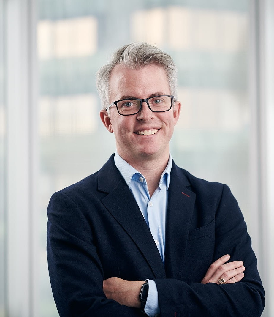 Un hombre está de pie con los brazos cruzados.