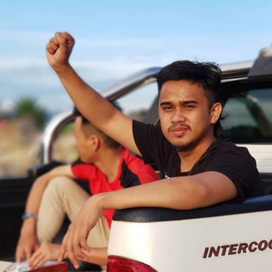 A man holds up his fist while posing for a photo