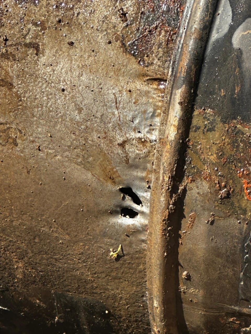 A thin part of a metal pipe where holes have formed.