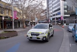 A police car drives down an empty street 
