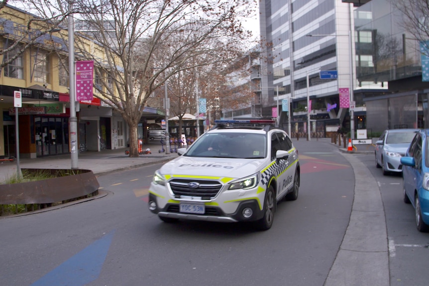 A police car drives down an empty street 