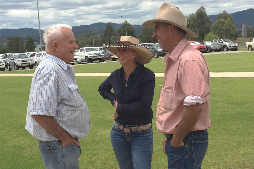 Hereford breeder John Hurley stands with Rebecca and Steven Cadzow. All are smiling.