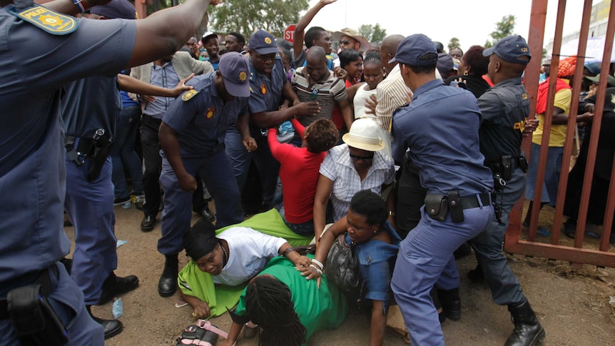 Mourners break through a barrier to try and see Mandela