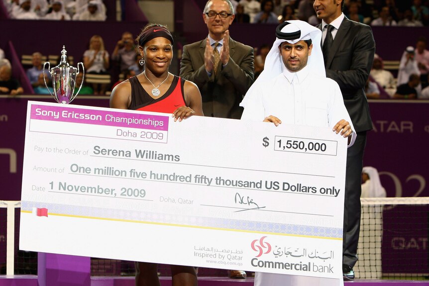 Serena Williams and Nasser al-Khulaifi hold up a large cheque after the Sony Ericsson Championships.