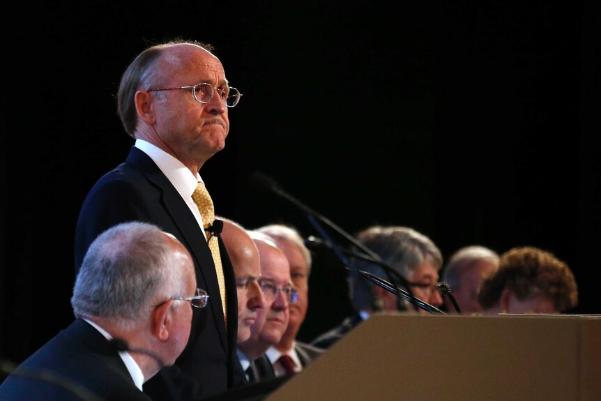 Jan du Plessis stands at the podium, surrounded by Rio Tinto board members