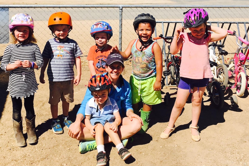 Young kids wearing bike helmets on an excursion.