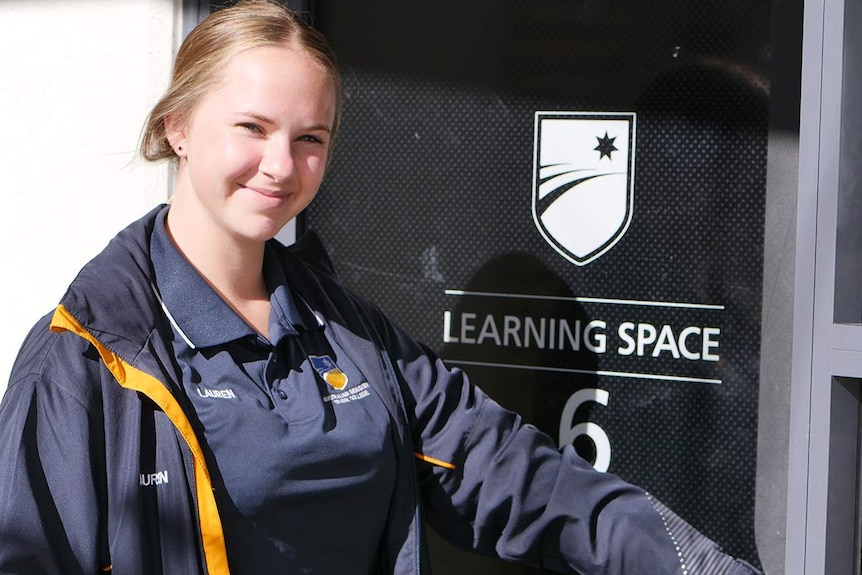 Young woman with uniform and her name lauren walking into a door that says learning space with the number 6