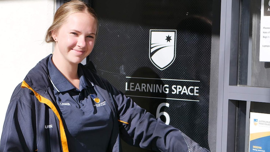 Young woman with uniform and her name lauren walking into a door that says learning space with the number 6