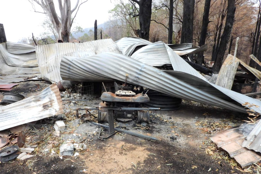 The remains of a burnt property, including twisted tin roofing.