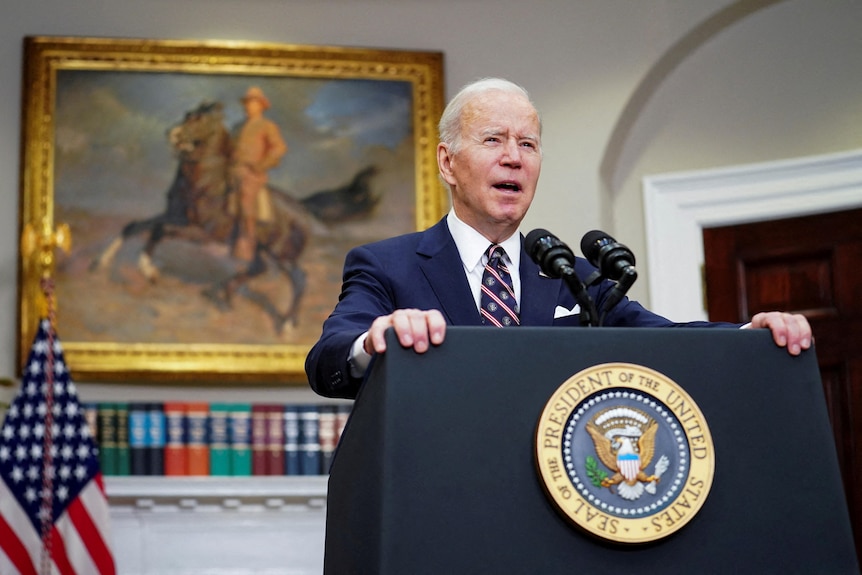 Joe Biden speaking at podium in White House.
