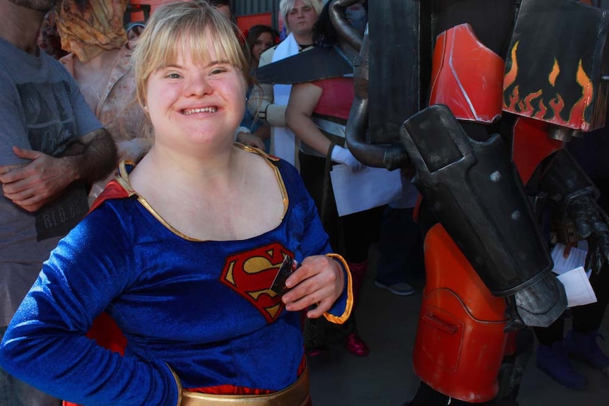 girl in super woman outfit with a huge grin on her face