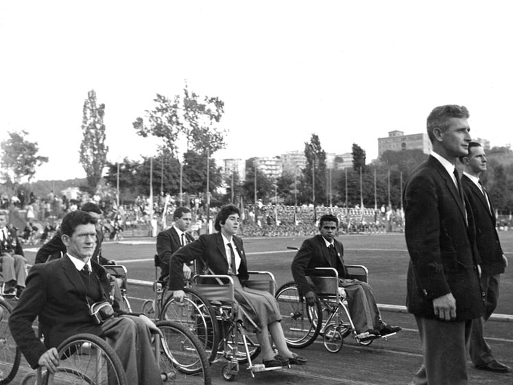 Athletes in wheelchairs move across a sporting field , at a Paralympic Games.