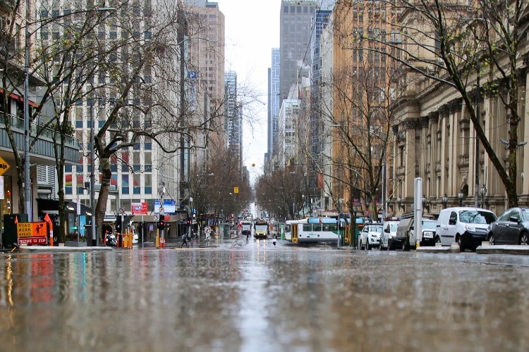 A photo at road level of a rainy, empty street in Melbourne's CBD.