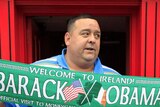 A man holds a US president Barack Obama souvenir scarf outside a pub in Moneygall, Ireland