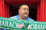 A man holds a US president Barack Obama souvenir scarf outside a pub in Moneygall, Ireland