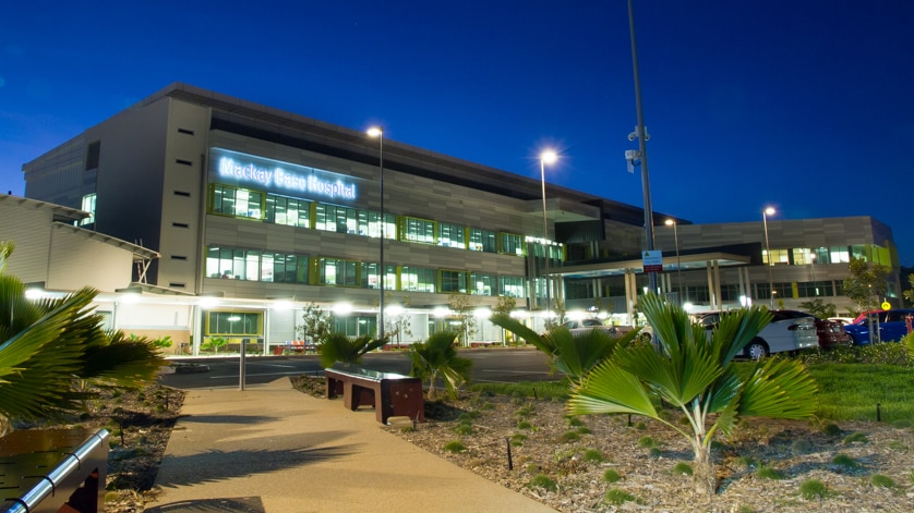 A photo of the outside of the Mackay Base Hospital lit up at night time