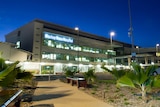 A photo of the outside of the Mackay Base Hospital lit up at night time
