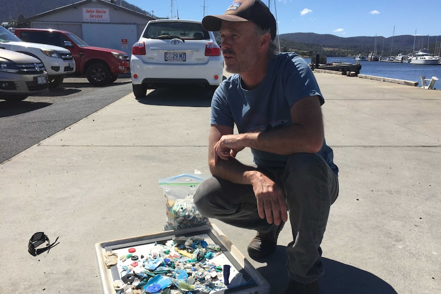 Clean-up organiser Matt Dell on the wharf with some of the beach litter