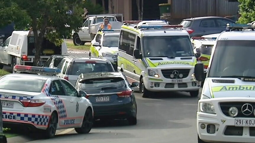 Police and ambulance vehicles in a suburban street in Cairns.