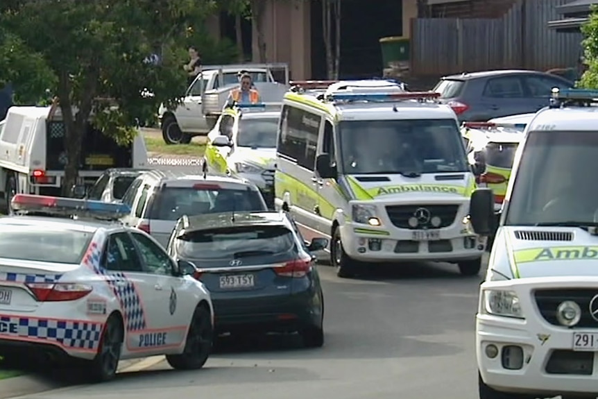 Police and ambulance vehicles in a suburban street in Cairns.