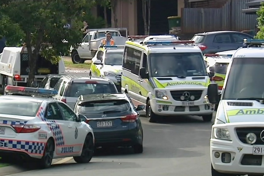 Police and ambulance vehicles in a suburban street