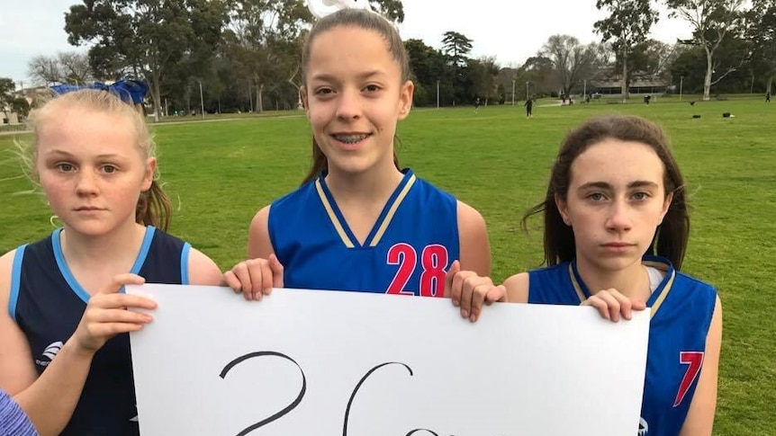 Young netballers hold up a sign calling for more facilities in the Stonnington area.