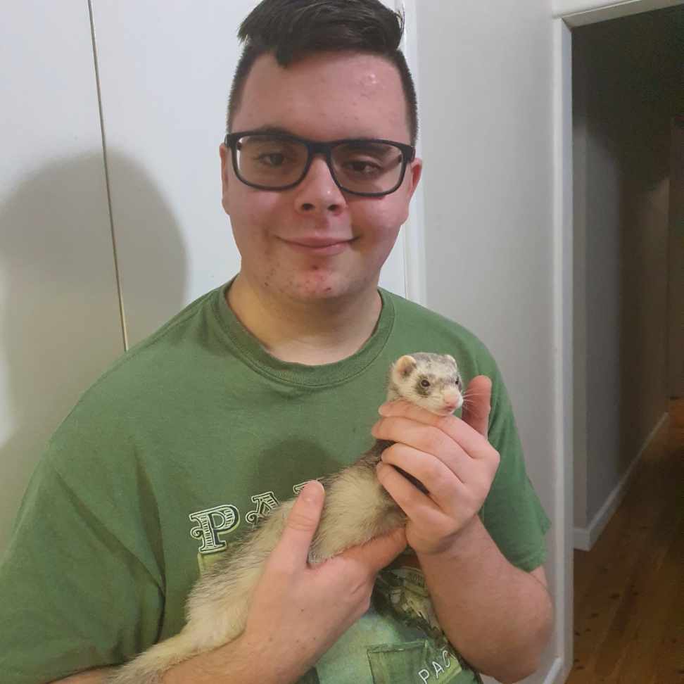 Close up shot of Xavier Hamilton holding his pet ferret Trixie