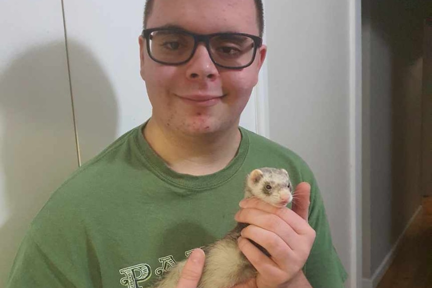Close up shot of Xavier Hamilton holding his pet ferret Trixie
