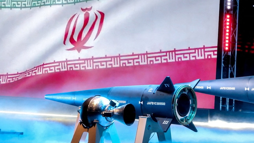 The Iranian flag  is shown with the new hypersonic missile called "fattah'.