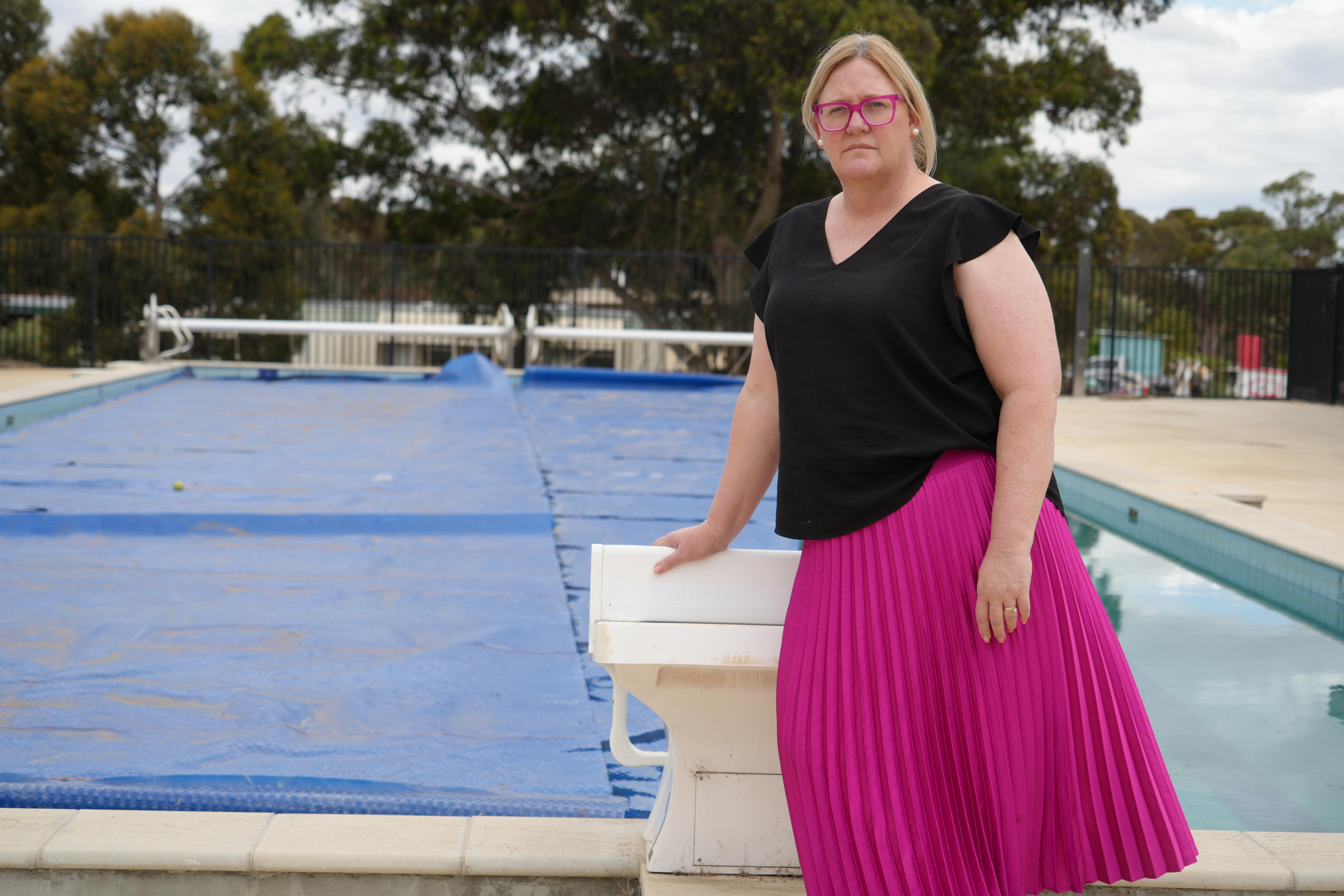 Caroline Phillips leans on diving platform in front of the Karoonda pool which is half covered with pool cover.