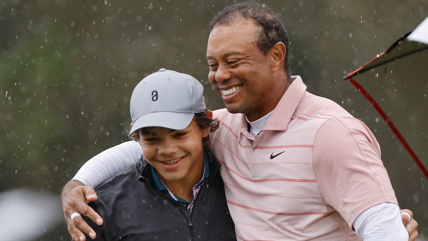 Tiger Woods with his arm around the shoulder of his son Charlie at a tournament.