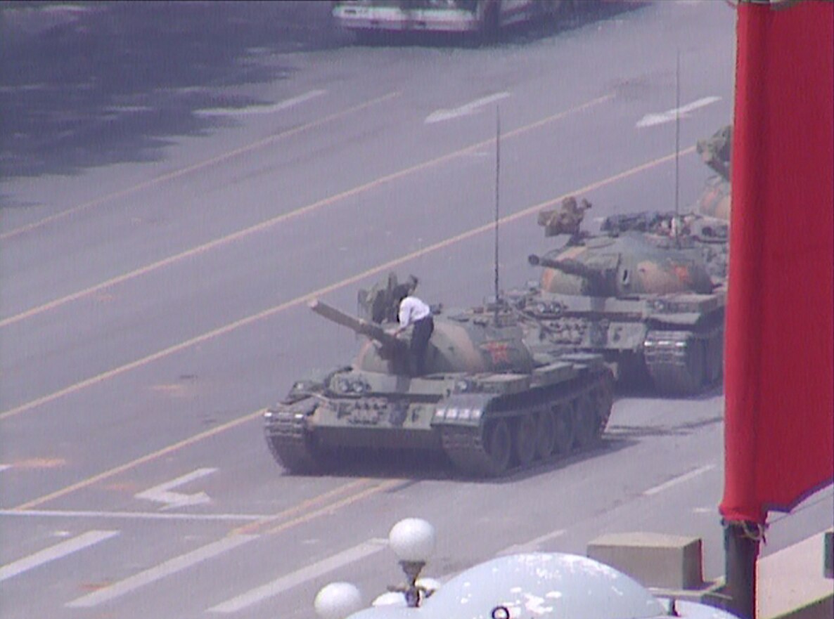 A man climbs aboard an army tank during pro-democracy protests in Tiananmen Square