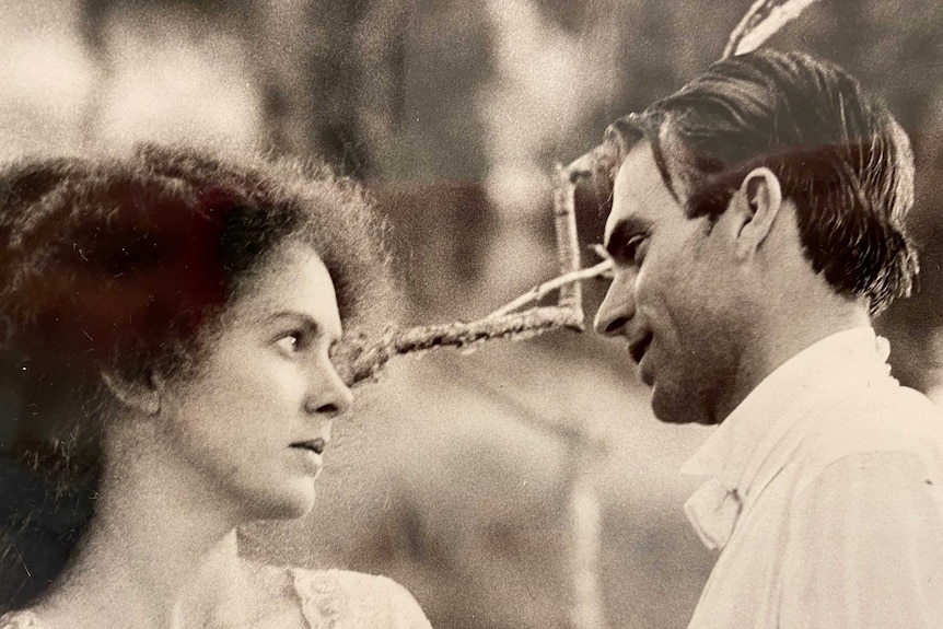 Black and white photo of Davis and Neill in scene from film looking lovingly at each other.