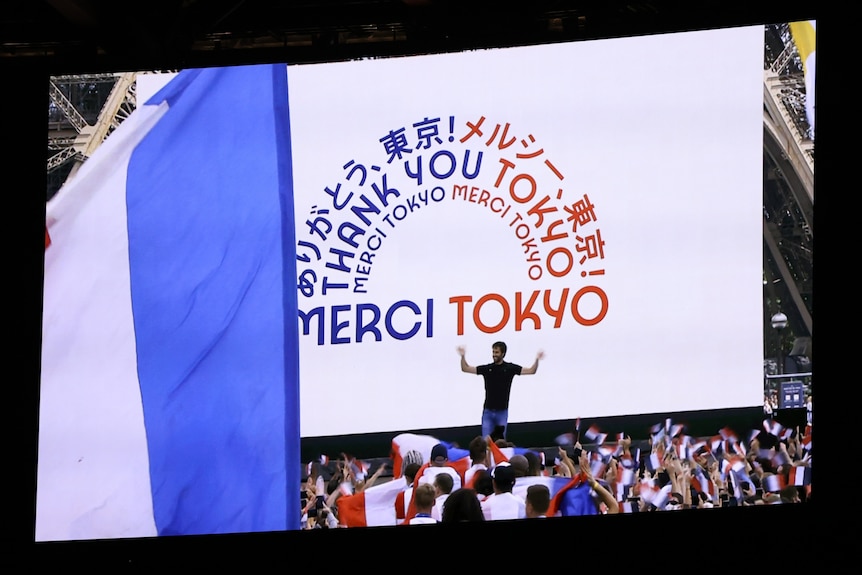 A thank you sign in English, French and Japanese on the Paris 2024 video at the Tokyo Olympics closing ceremony.