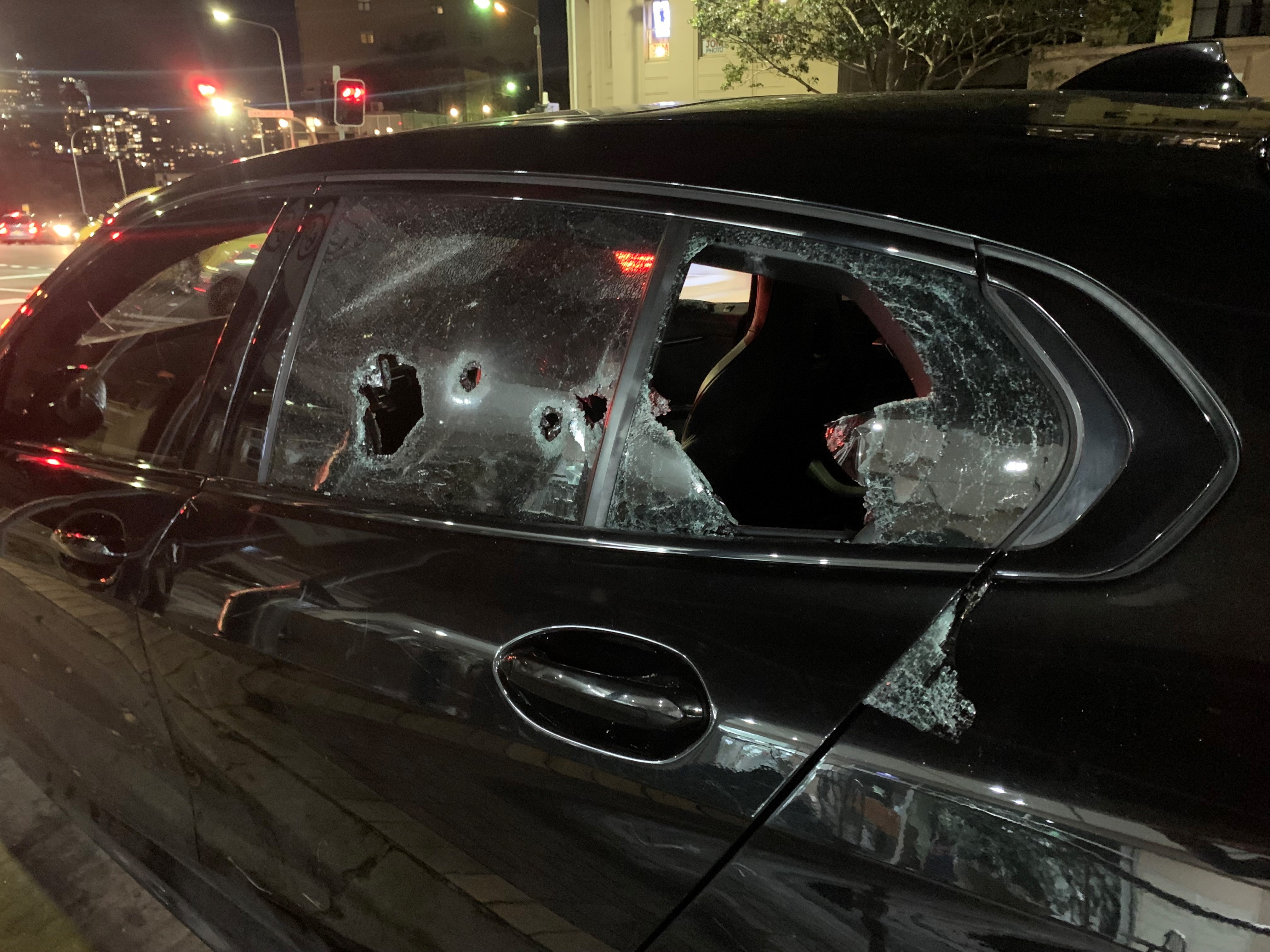 a black car with shots in its window and side of the car