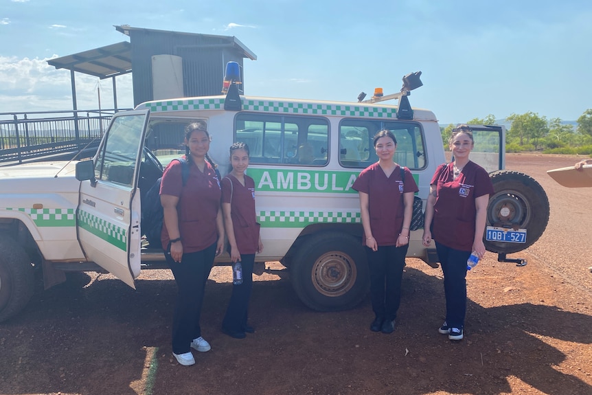 four nurses in front of a Toyota Troop Carrier ambulance 